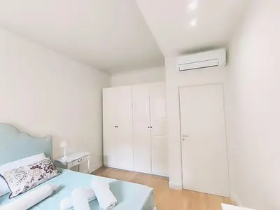 a white bedroom with a bed and a white closet at Elegant apartment 5 minutes from the subway in Rome