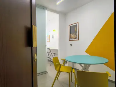 a dining room with a table and yellow chairs at Casa di Eu - WelcomeToRhome in Rome