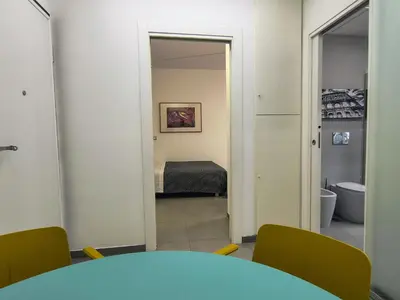 a room with a table and chairs and a bedroom at Casa di Eu - WelcomeToRhome in Rome