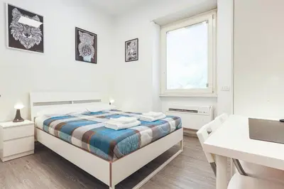 a white bedroom with a bed and a window at San Giovanni rooms in Rome