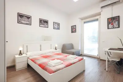 a bedroom with a bed with a colorful striped blanket at San Giovanni rooms in Rome