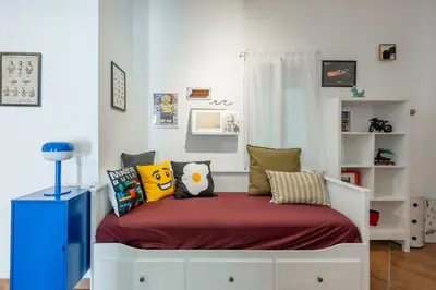 a bedroom with a bed with pillows on it at NOSTROMONDO-Playful & Modern Apartment in the heart of Pigneto in Rome