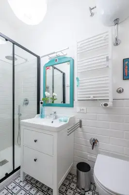 a white bathroom with a sink and a mirror at NOSTROMONDO-Playful & Modern Apartment in the heart of Pigneto in Rome