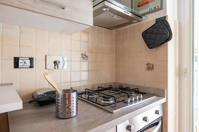 a kitchen with a stove and a pot on the counter at NOSTROMONDO-Playful & Modern Apartment in the heart of Pigneto in Rome