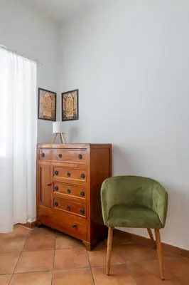a chair next to a dresser and a dresser at NOSTROMONDO-Playful & Modern Apartment in the heart of Pigneto in Rome