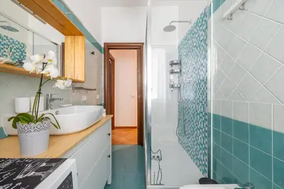 a bathroom with a white sink and a shower at NOSTROMONDO-Playful & Modern Apartment in the heart of Pigneto in Rome