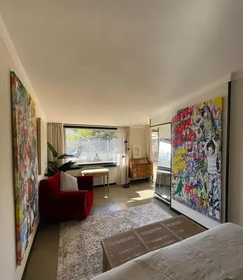 a bedroom with a bed and a red chair and a living room at Da Brando Loft PONTE MILVIO in Rome