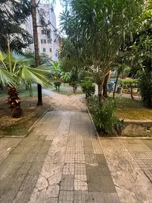 a brick path in a park with trees and buildings at Imera House City Retreat in Rome
