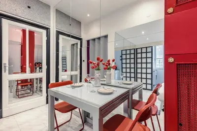 a dining room with a white table and red chairs at San Pietro Apartment Vatican 5 min Walk in Rome