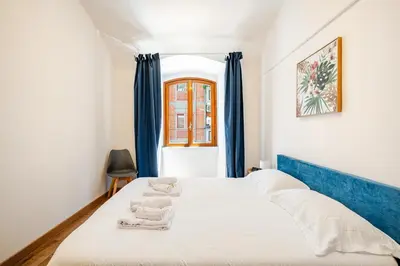 a bedroom with two beds with blue curtains at Colosseo Comfort e Stile in centro a Roma in Rome