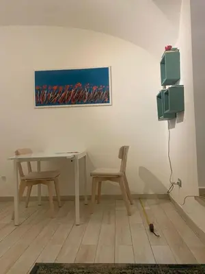 a room with a table and two chairs and a painting at PIRAMIDE apartment in Rome