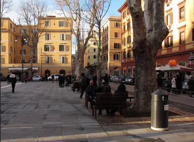 a group of people sitting on benches next to a tree at PIRAMIDE apartment in Rome