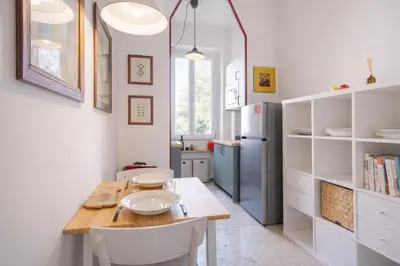 a kitchen with a table and a refrigerator at Elegantis Gallo Suite Apartment - Few steps from the Vatican in Rome