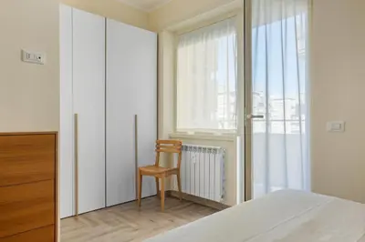 a bedroom with a bed and a chair next to a window at Conca D'Oro Guest House - Stefania in Rome