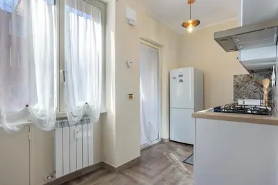 a kitchen with a refrigerator and a counter top at Conca D'Oro Guest House - Stefania in Rome