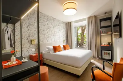 a bedroom with a bed and a desk and a window at Urban Garden Suites in Rome