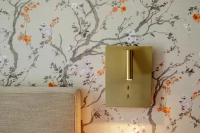 a switch on a wall with a floral wallpaper at Urban Garden Suites in Rome