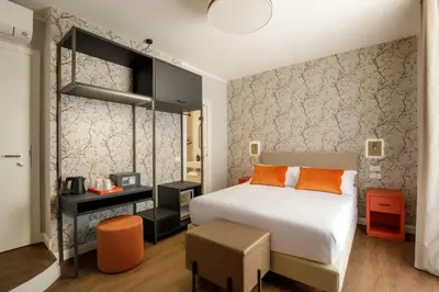 a bedroom with a bed and a table with a stool at Urban Garden Suites in Rome