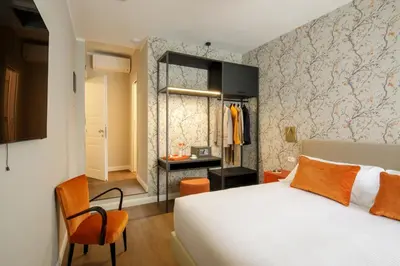 a hotel room with a bed and a chair and a bedroom at Urban Garden Suites in Rome