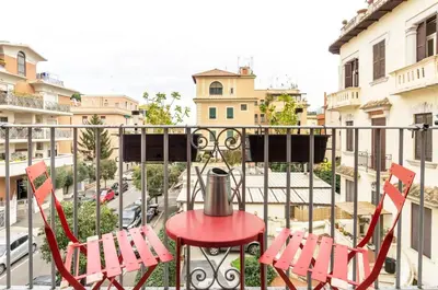 two red chairs and a table on a balcony at Panorama Home in Rome