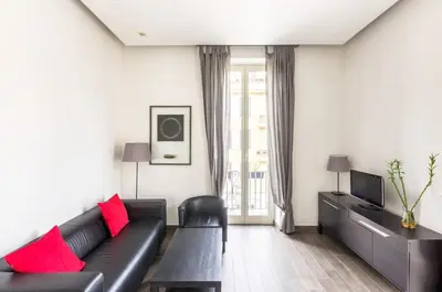 a living room with a black couch and red pillows at Panorama Home in Rome