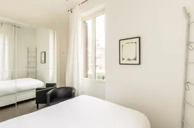 a bedroom with a bed and a chair and a window at Panorama Home in Rome