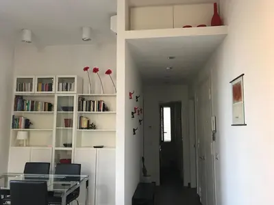 a dining room with a table and a book shelf at Panorama Home in Rome