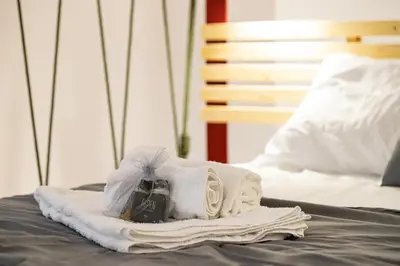 a pile of towels on top of a bed at Monolocale moderno a 2 min dalla metro B in Rome