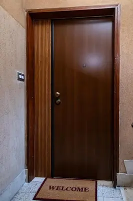 a wooden door with a welcome sign in front of it at Monolocale moderno a 2 min dalla metro B in Rome