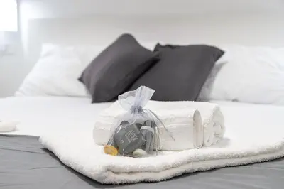 a white towel with a box on a bed at Moderno e centrale, a 2 min dalla metro B in Rome