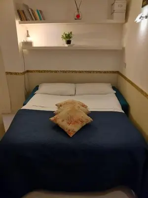 a bed with a blue blanket and a pillow on it at Domus Pantheon in Rome