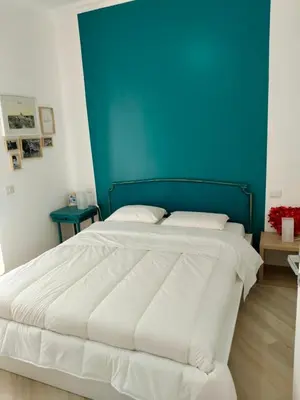 a bedroom with a large bed with a blue wall at Vatican Museum Home in Rome