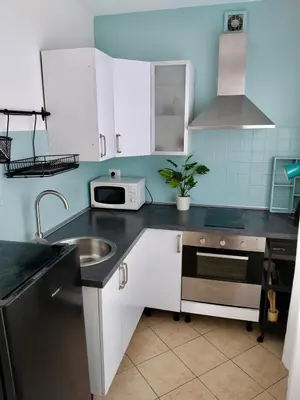 a kitchen with white cabinets and a sink at Vatican Museum Home in Rome