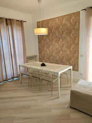 a dining room with a white table and chairs at Vatican Museum Home in Rome