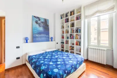 a bedroom with a bed and a book shelf at St John Home in Rome