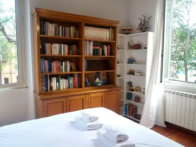 a book shelf with two towels on a bed in a room at St John Home in Rome