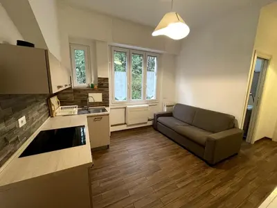 a living room with a couch and a kitchen at Dream Forest in Rome