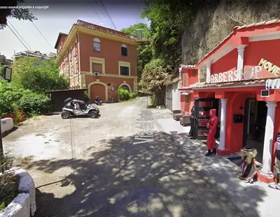 a street with red buildings and a motorcycle parked on the road at Dream Forest in Rome