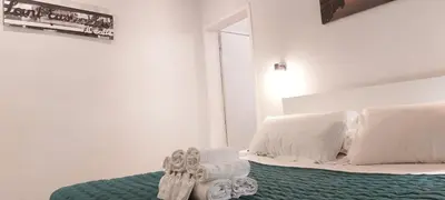a white bedroom with a bed with white pillows at Navona Cozy Apartment in Rome