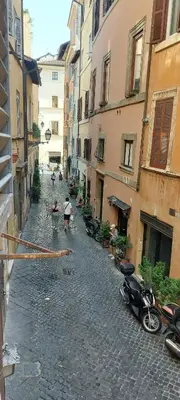 a street with buildings and people with umbrellas at Navona Cozy Apartment in Rome