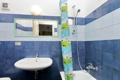a blue tiled bathroom with a sink and a mirror at Le Rondinelle di Trastevere in Rome