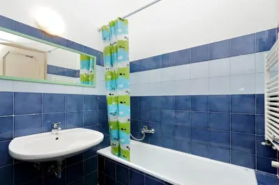 a blue tiled bathroom with a sink and a tub at Le Rondinelle di Trastevere in Rome
