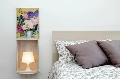 a bedroom with a bed with a lamp and a picture at Le Rondinelle di Trastevere in Rome