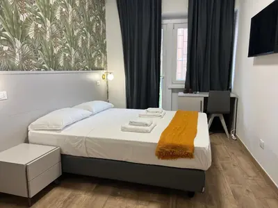 a bedroom with a bed with a yellow blanket on it at Qg Golden Rooms in Rome