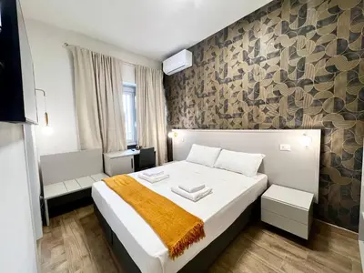 a bedroom with a large bed and a stone wall at Qg Golden Rooms in Rome