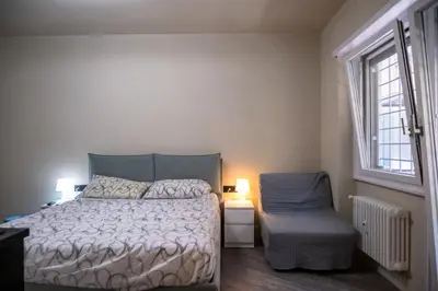 a bedroom with a bed and a chair and a window at zampieri house camera verde in Rome