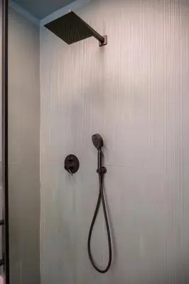 a shower with a hose attached to a wall at zampieri house camera verde in Rome