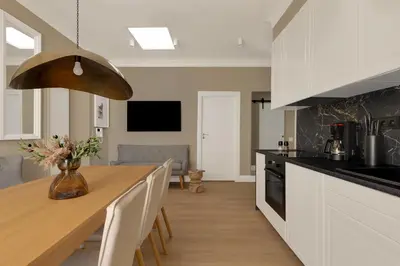 a kitchen with a wooden table and white cabinets at ROME City Center Apartment IV in Rome