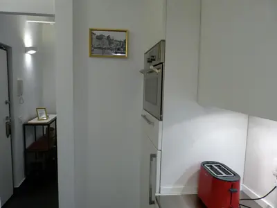 a kitchen with a refrigerator and a red trash can at The column of Campo de' Fiori in Rome