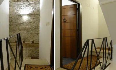 a stairway with a wooden door and a brick wall at The column of Campo de' Fiori in Rome